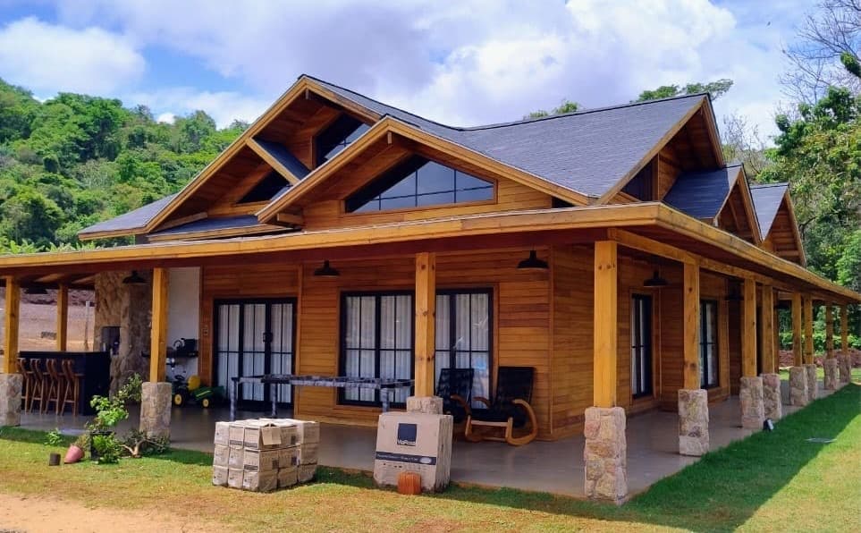 Casa de madeira ampla, com varanda e paisagismo, realizada pela empresa